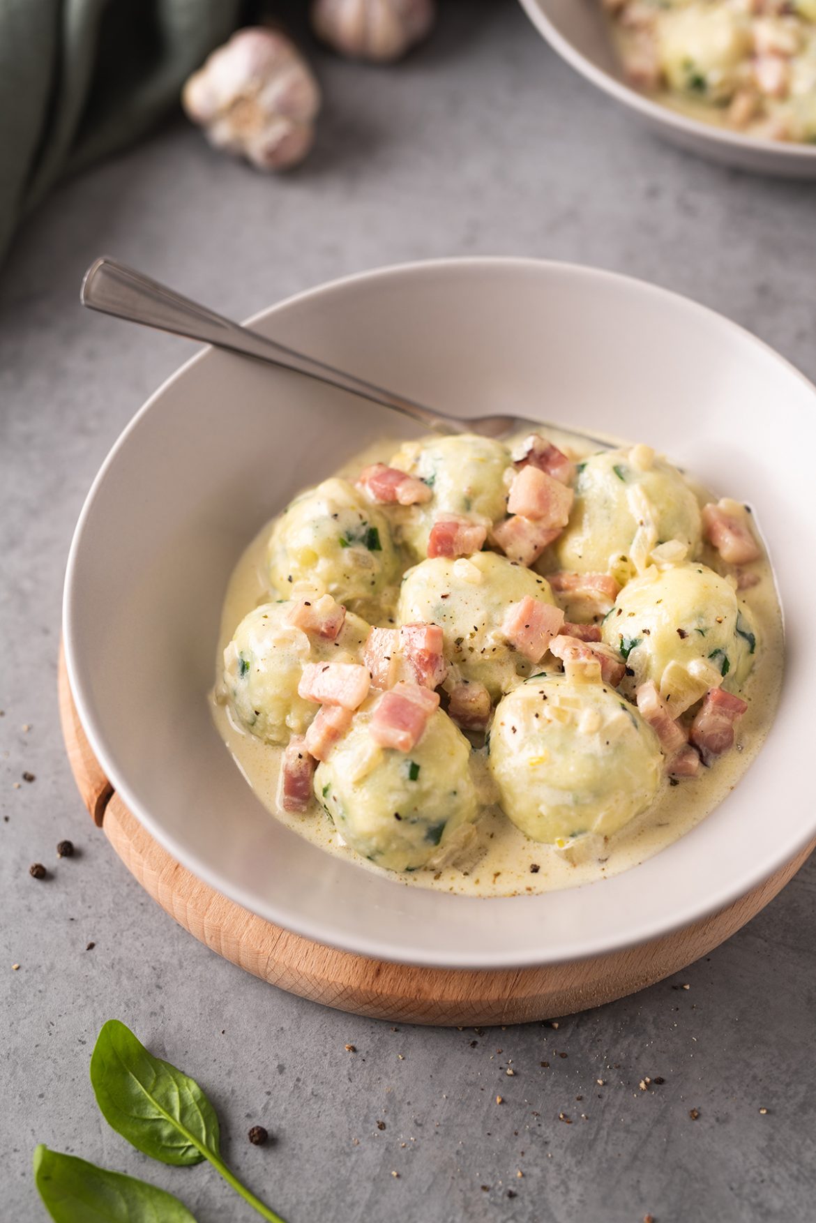 Bulvių ir varškės kukuliukai su špinatais ir šoninės padažu