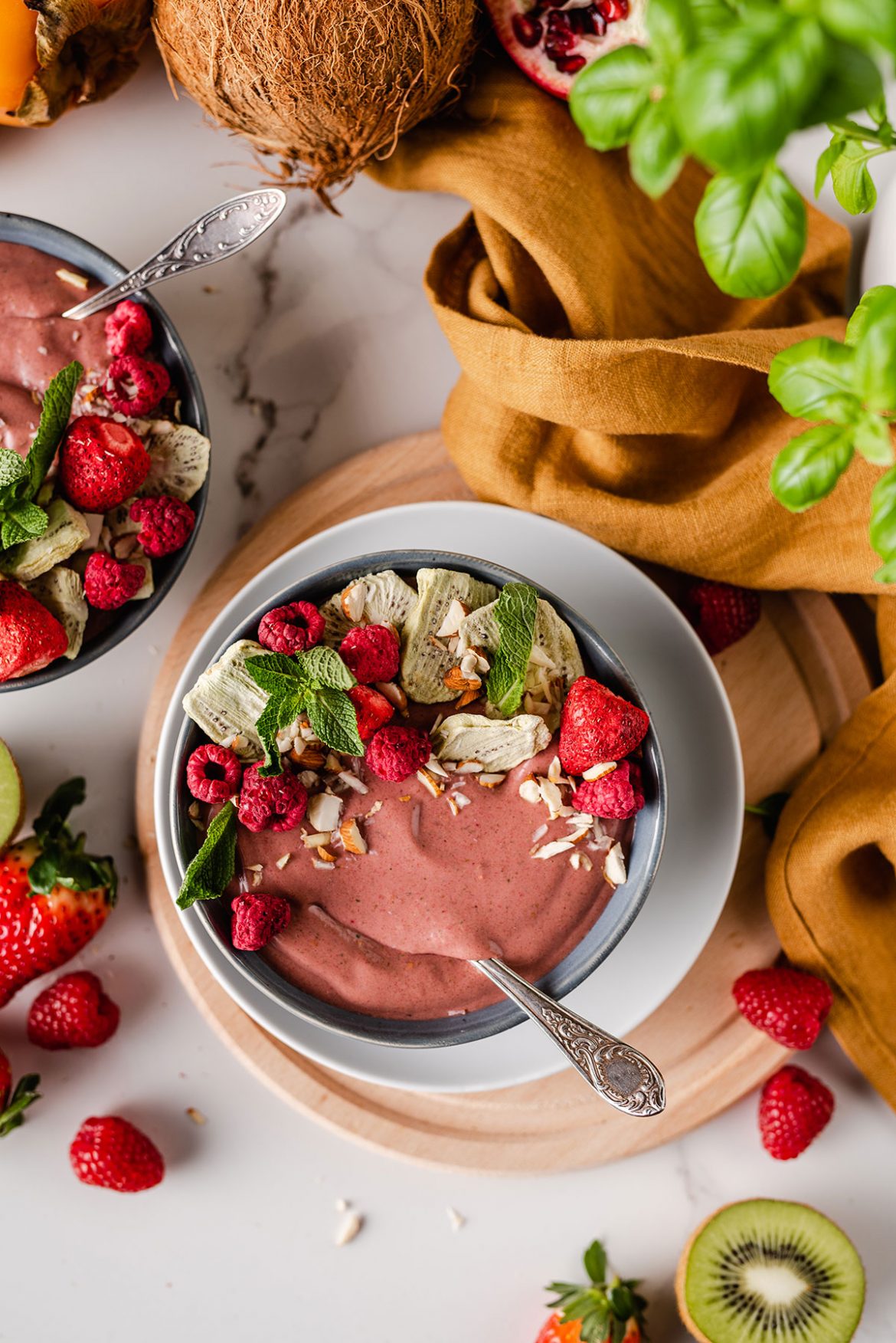 Uogų, bananų, špinatų, riešutų sviesto ir datulių kokteilis dubenėlyje